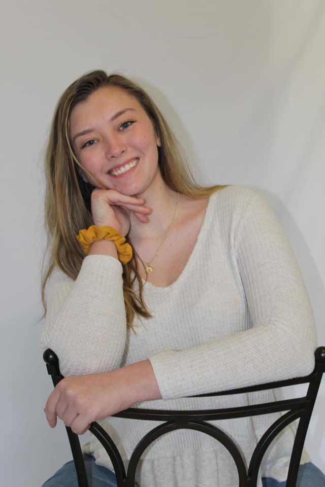 Picture of Kali Wright, author of website, sitting in a chair and smiling at the camera.